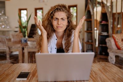 Woman has tech challenges at home Woman frustrated at home with laptop